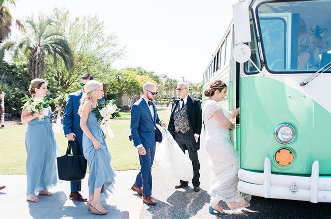 A group of people are standing next to a green and white bus.