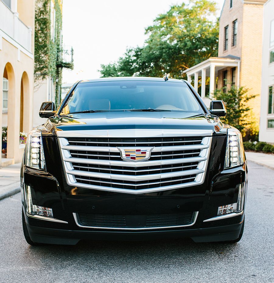 A black cadillac is parked on the side of the road