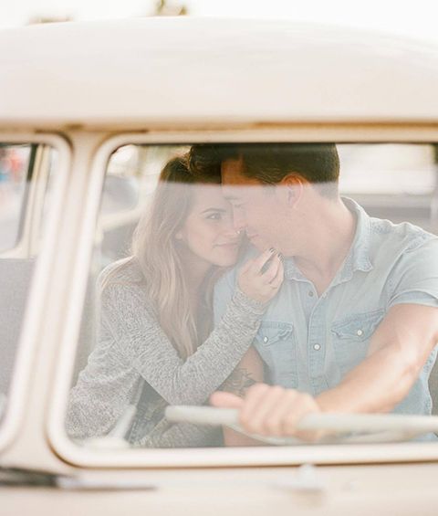 A man and a woman are sitting in the back seat of a car.