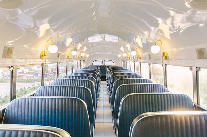 The inside of an empty school bus with blue seats.