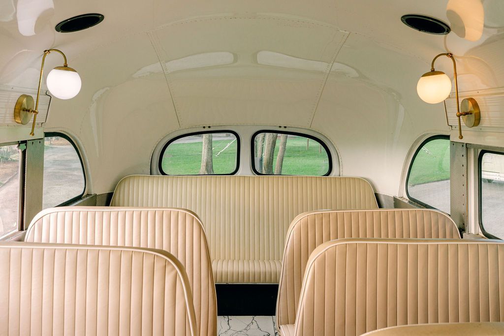 The inside of a bus with empty seats and a window.
