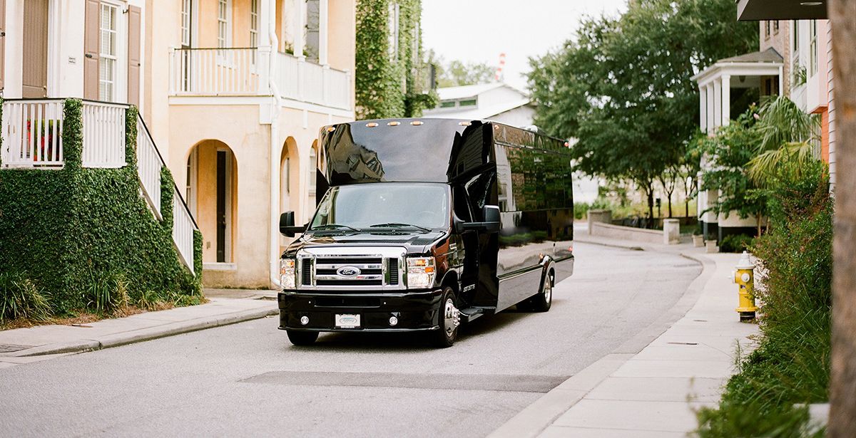 A black van is driving down a residential street.