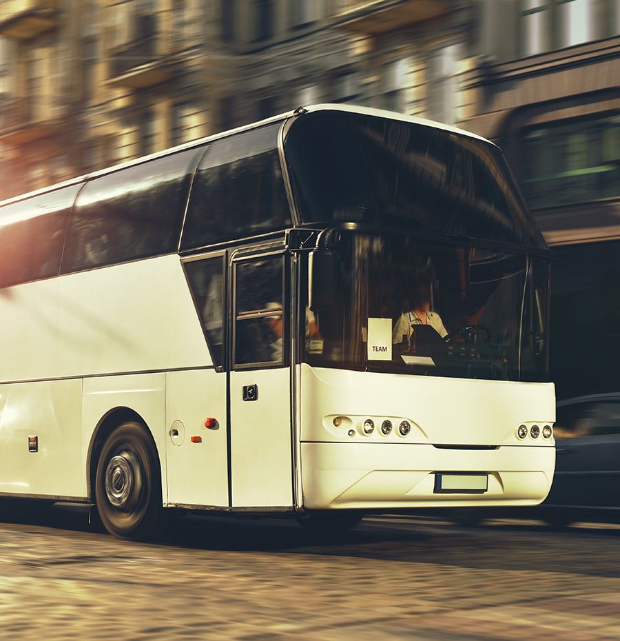 A white bus with the letter l on the front