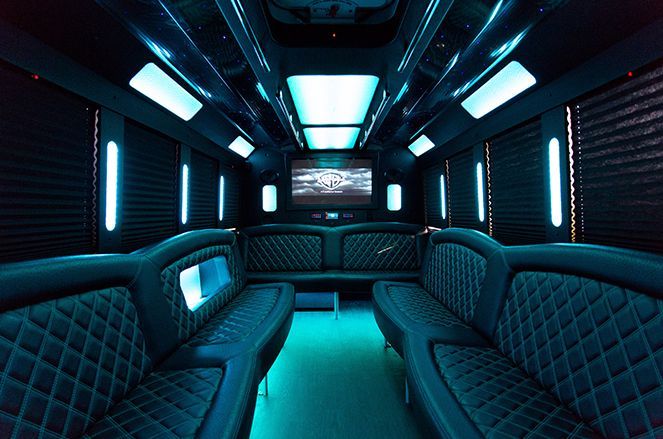 The inside of a limousine with blue lights and a flat screen tv.