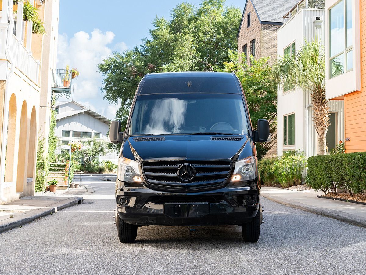 A black van is driving down a city street.