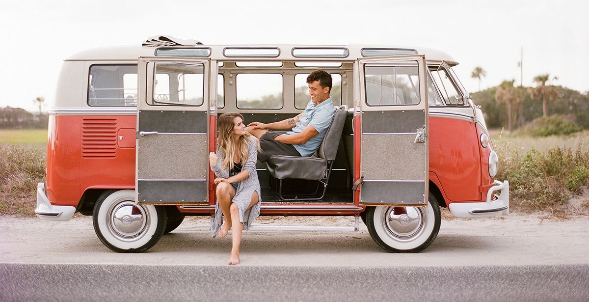 A man and a woman are sitting in a red van.