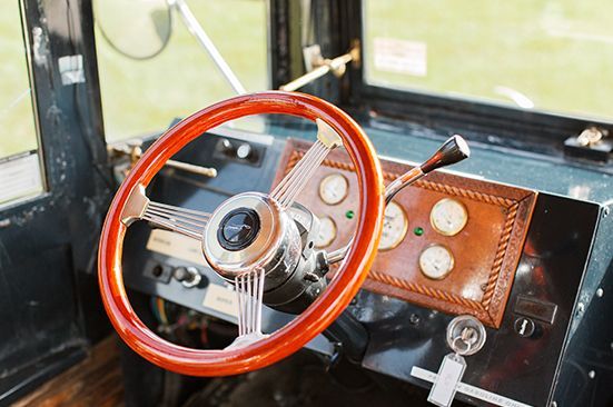 A close up of a wooden steering wheel in a car.