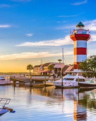 A red and white lighthouse is sitting on top of a body of water.