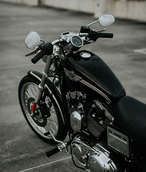 A black motorcycle is parked in a parking lot.