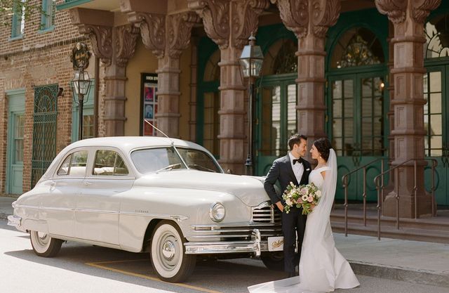 A man is driving a car with a wooden steering wheel.