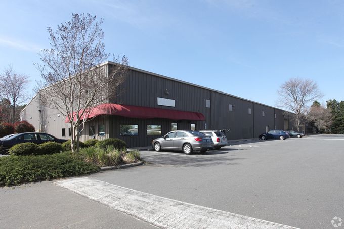 an aerial view of a large warehouse with cars parked in front of it .