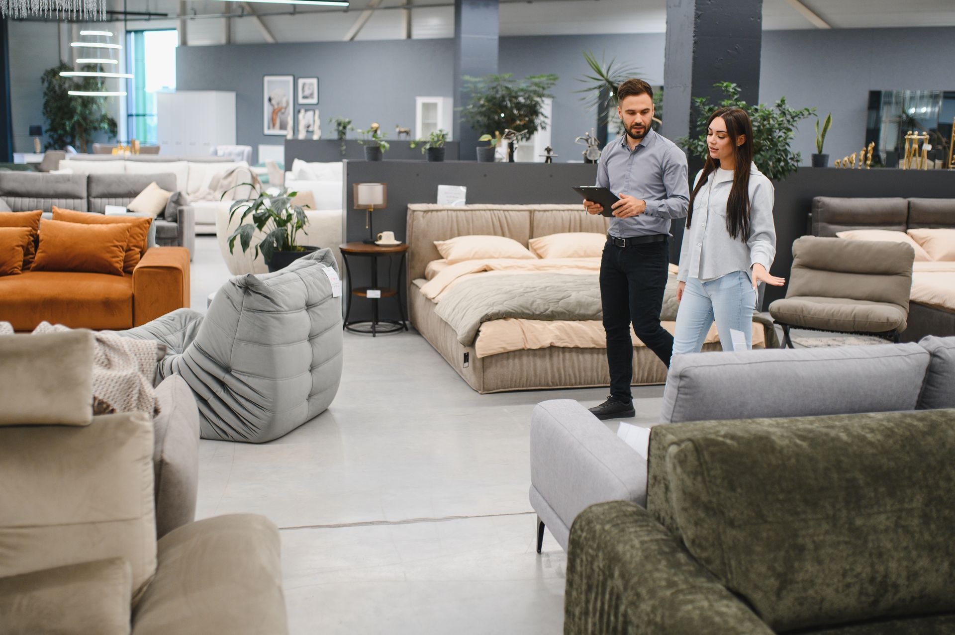 Customer and sales advisor discussing options in a furniture store showroom.