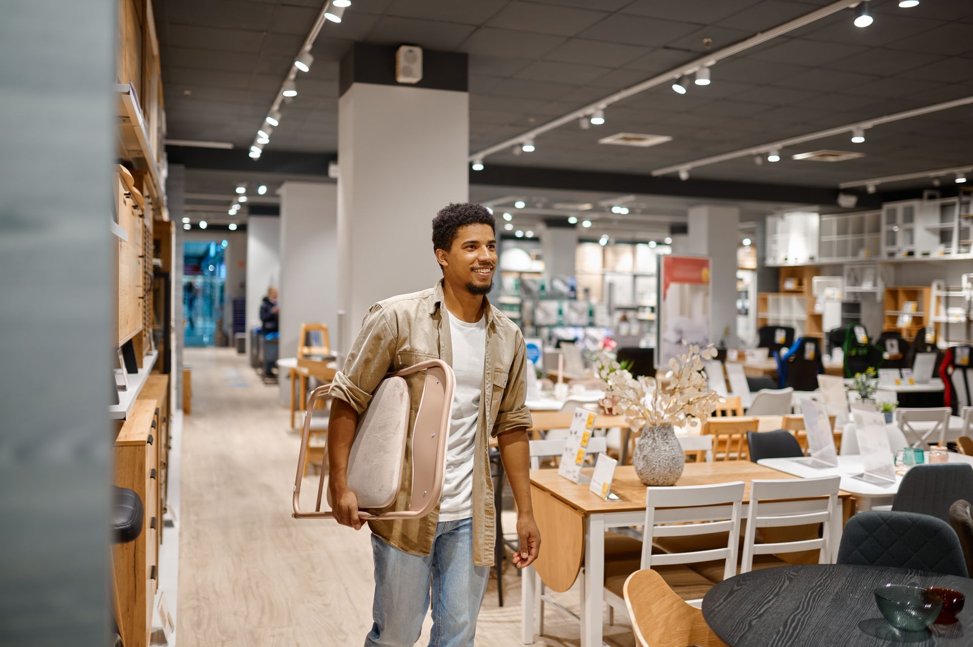 A man carrying a folding chair to the shop counter.