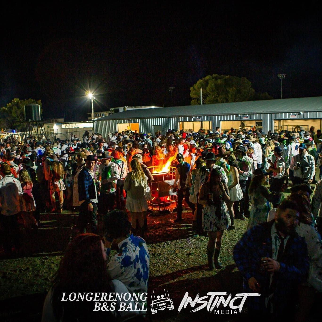 A large crowd of people are gathered at a longer nong b & s ball
