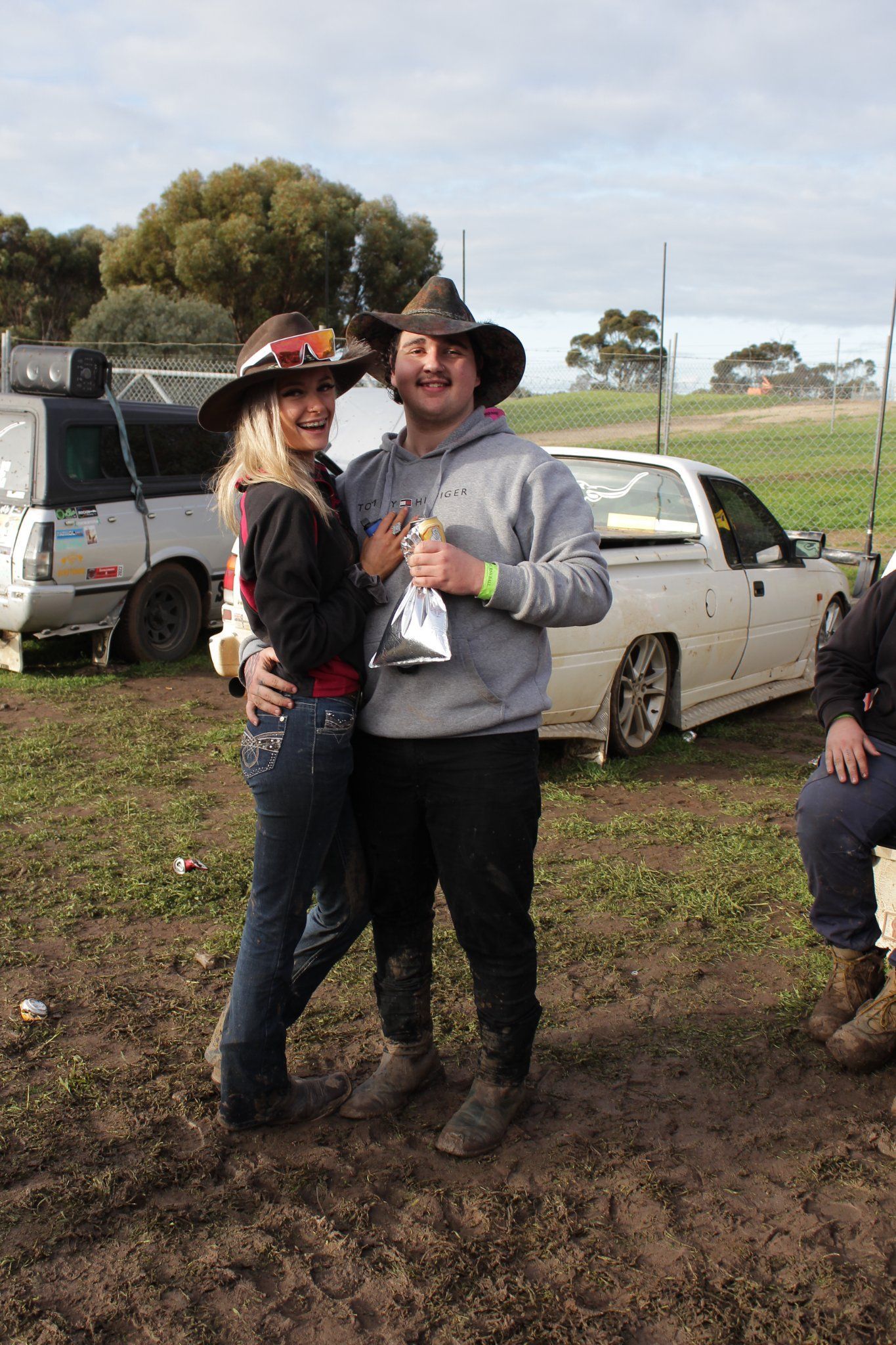 A man and a woman are posing for a picture in front of a truck