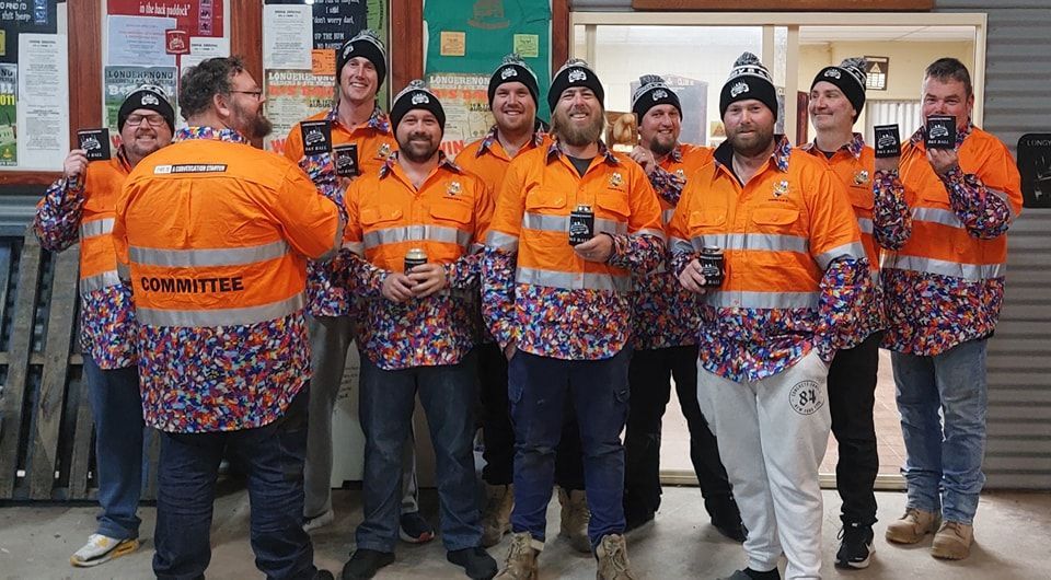 A group of men wearing orange shirts with the word privilege on them