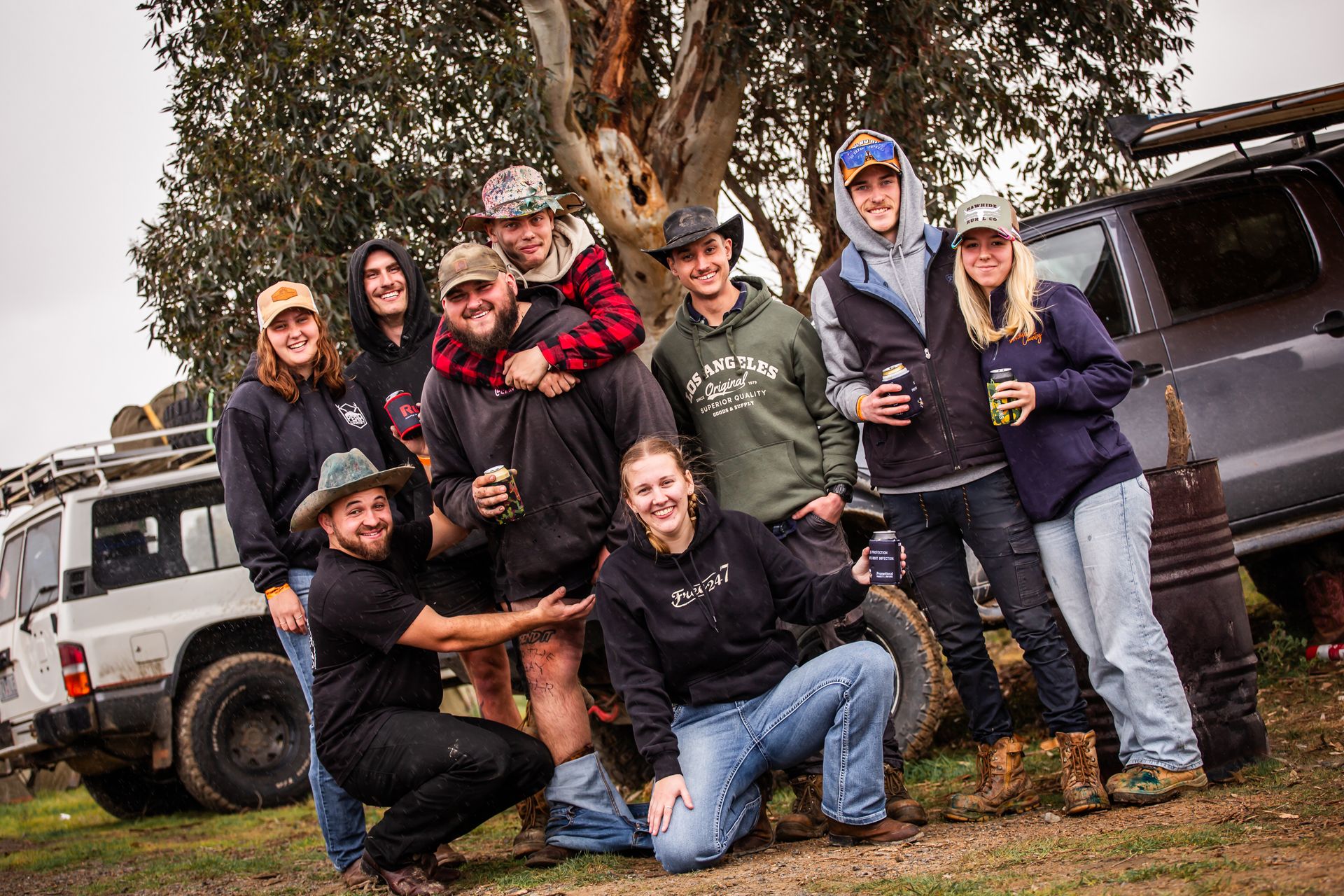 A group of people posing for a picture in front of a tree