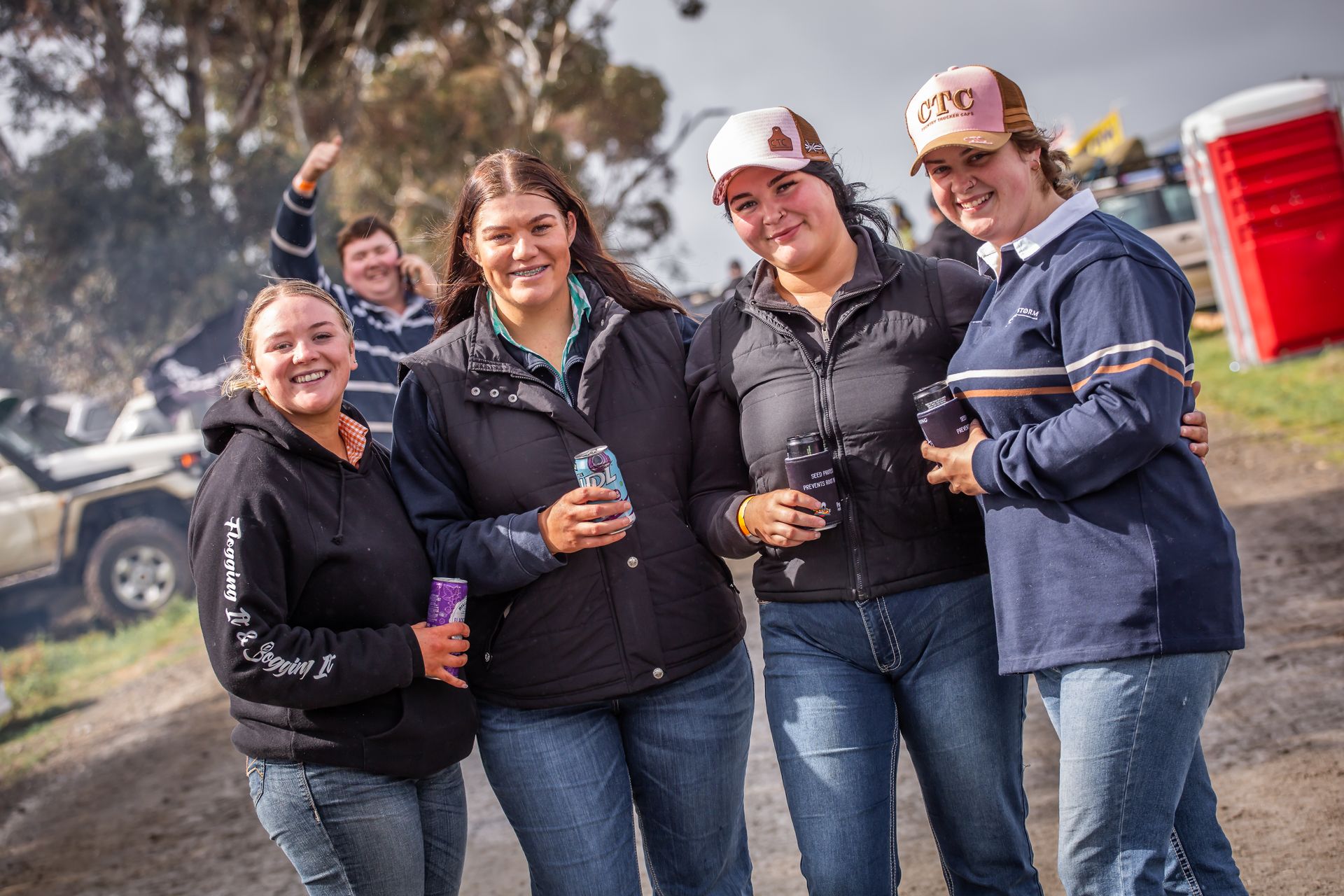 A group of women posing for a picture with one wearing a hat that says tco
