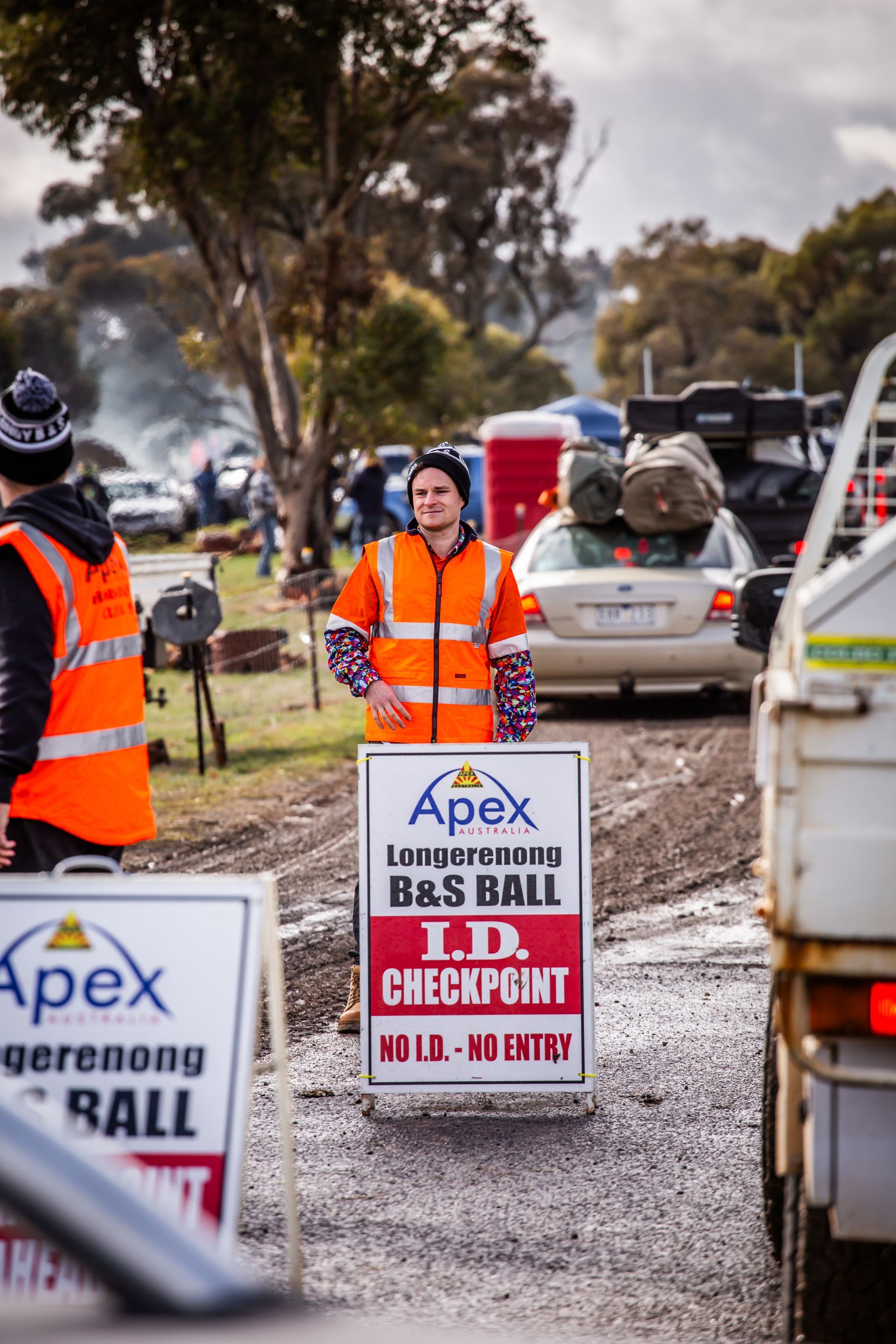 A man standing next to a sign that says apex
