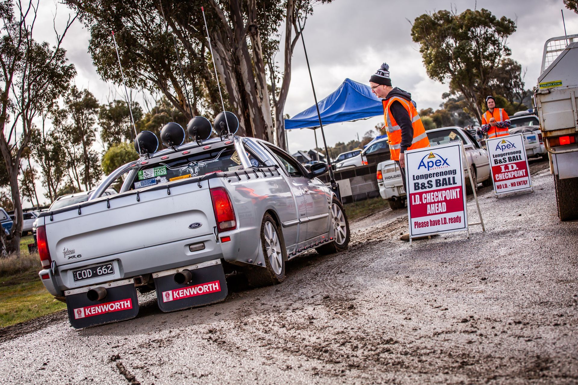 A silver pickup truck is parked next to a sign that says no loading on this road