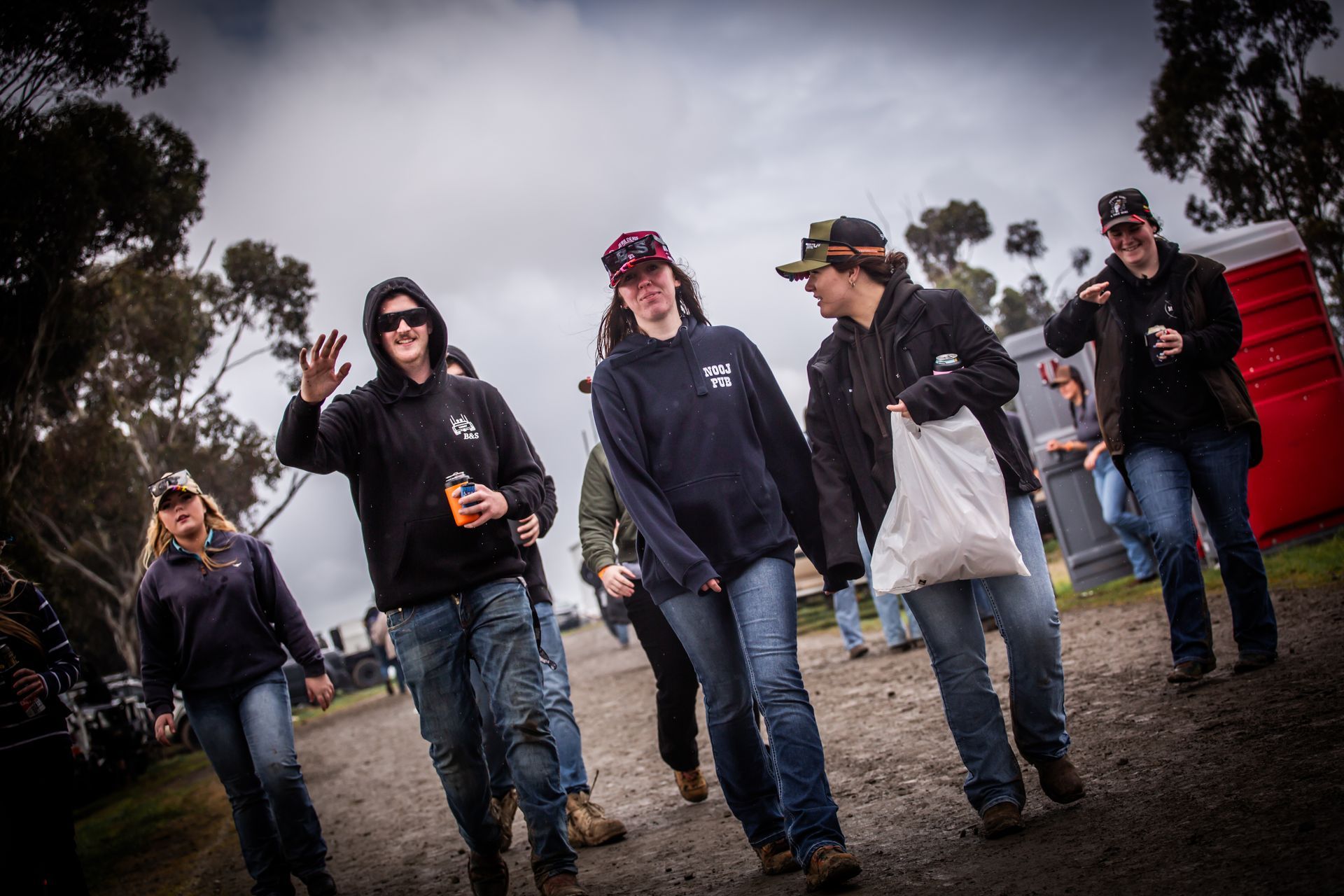 A group of people are walking down a dirt road