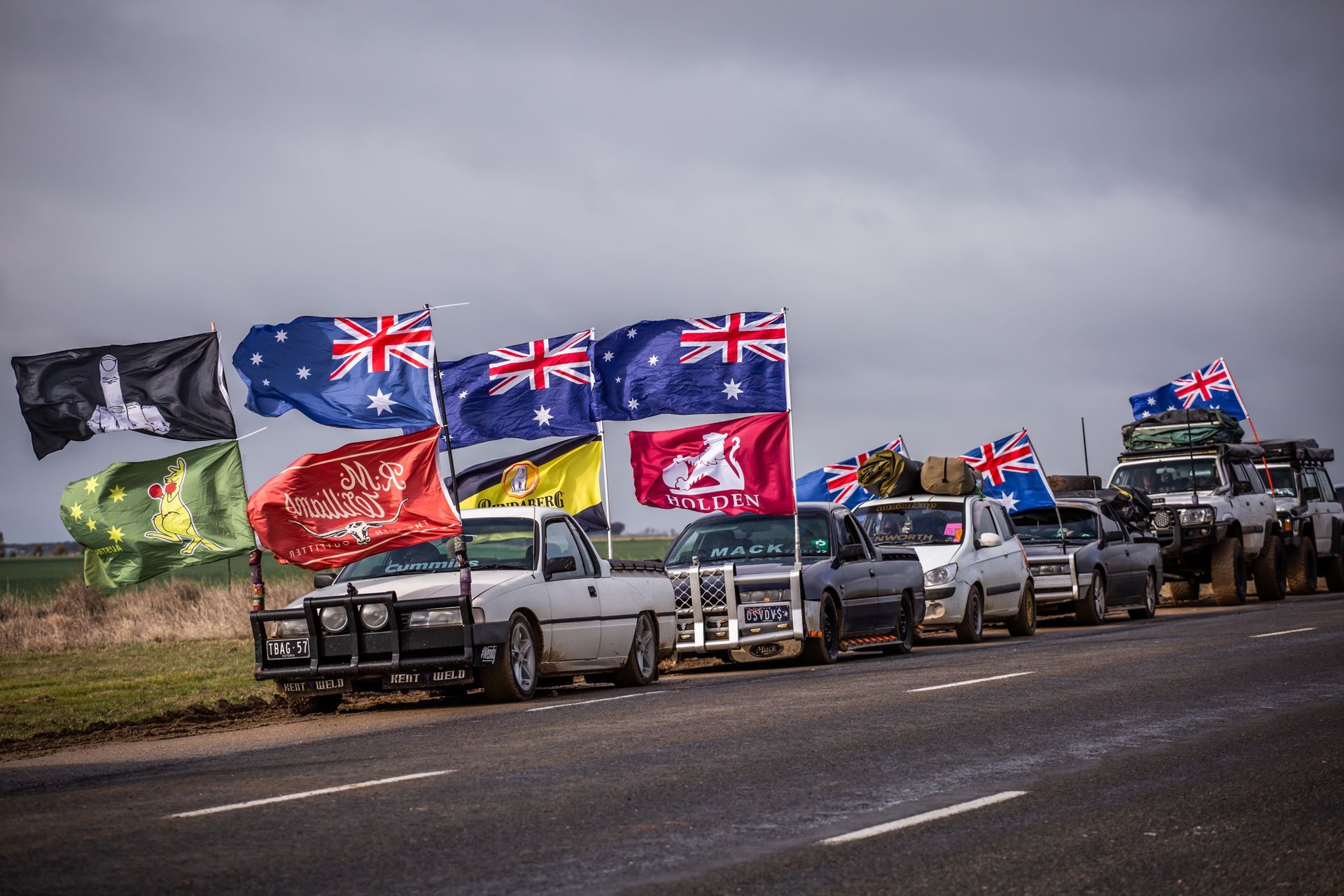 A row of trucks are parked on the side of the road