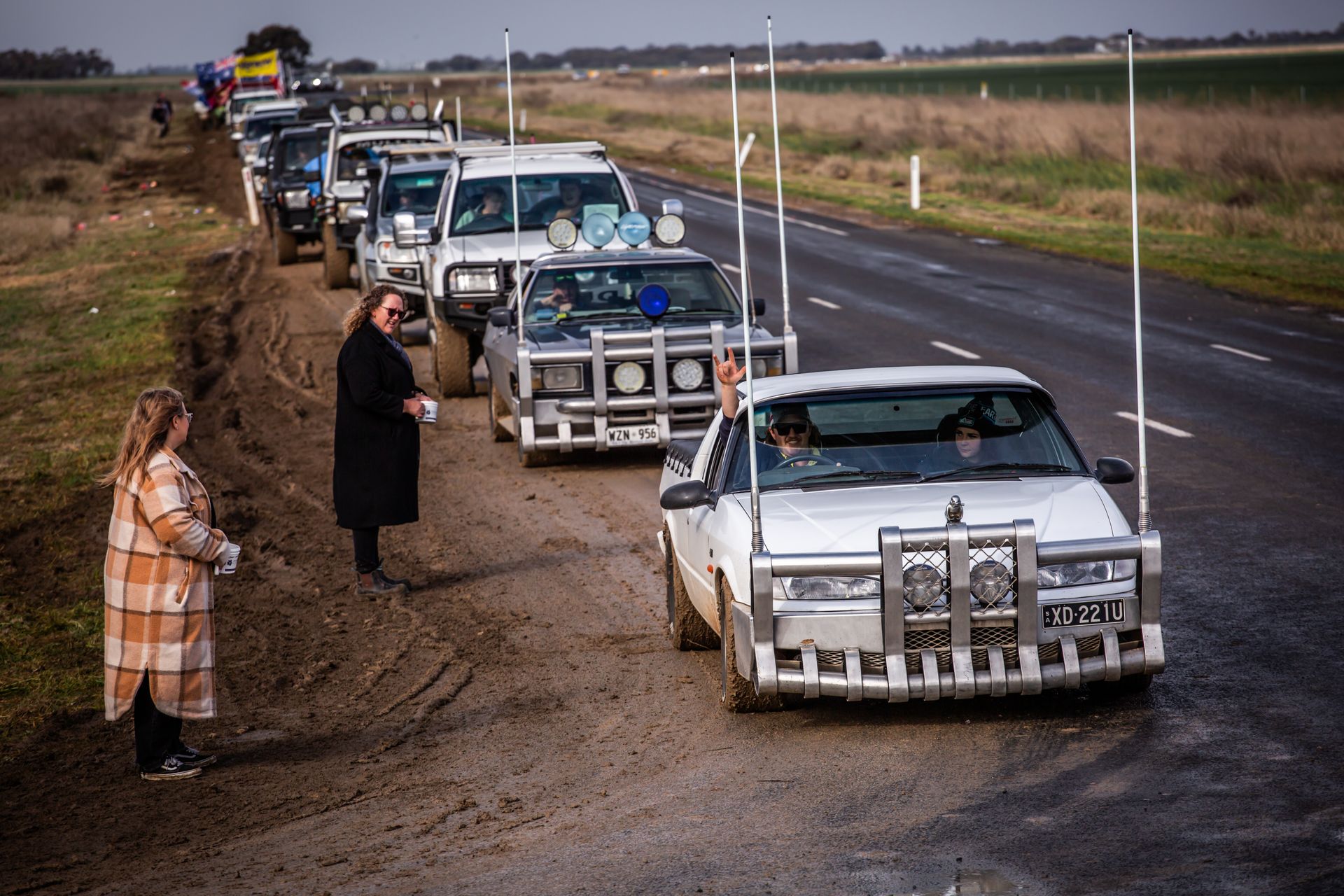 A row of cars are lined up on the side of the road