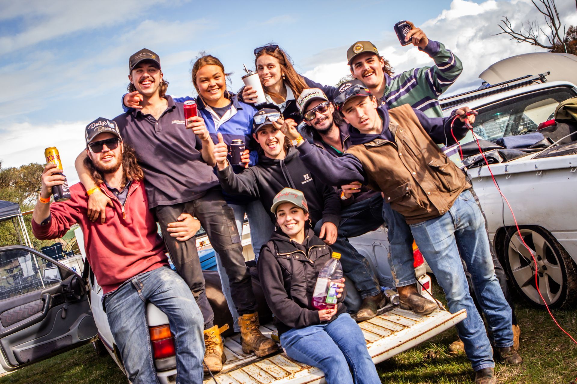 A group of people are posing for a picture while sitting in the back of a truck