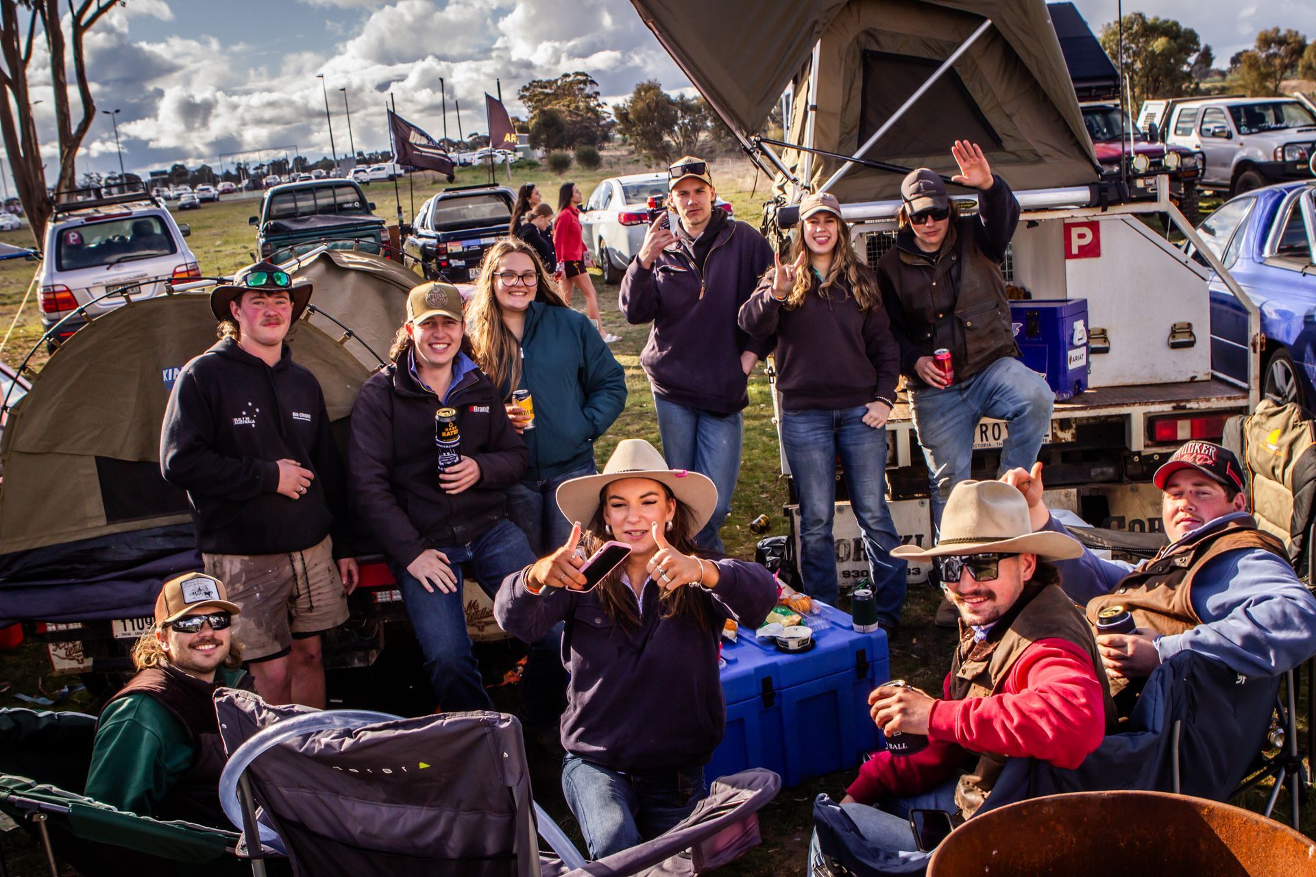 A group of people are posing for a picture in front of a tent that has the letter p on it