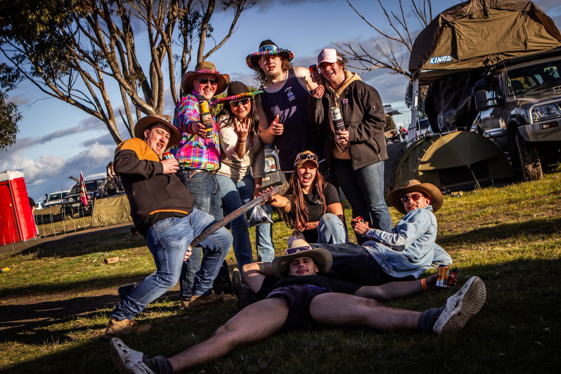 A group of people posing for a picture with one man laying on the ground