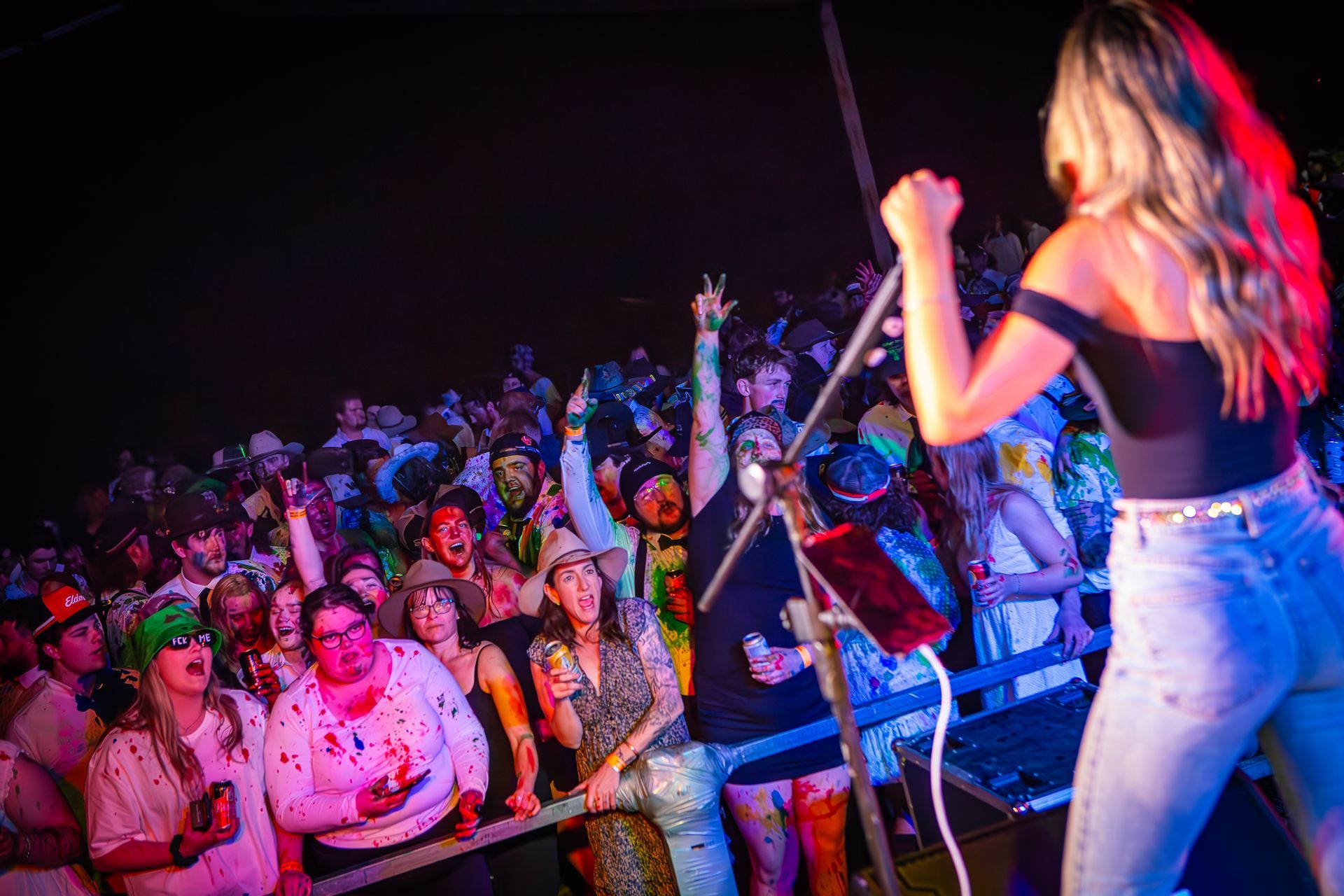 A woman singing into a microphone in front of a crowd