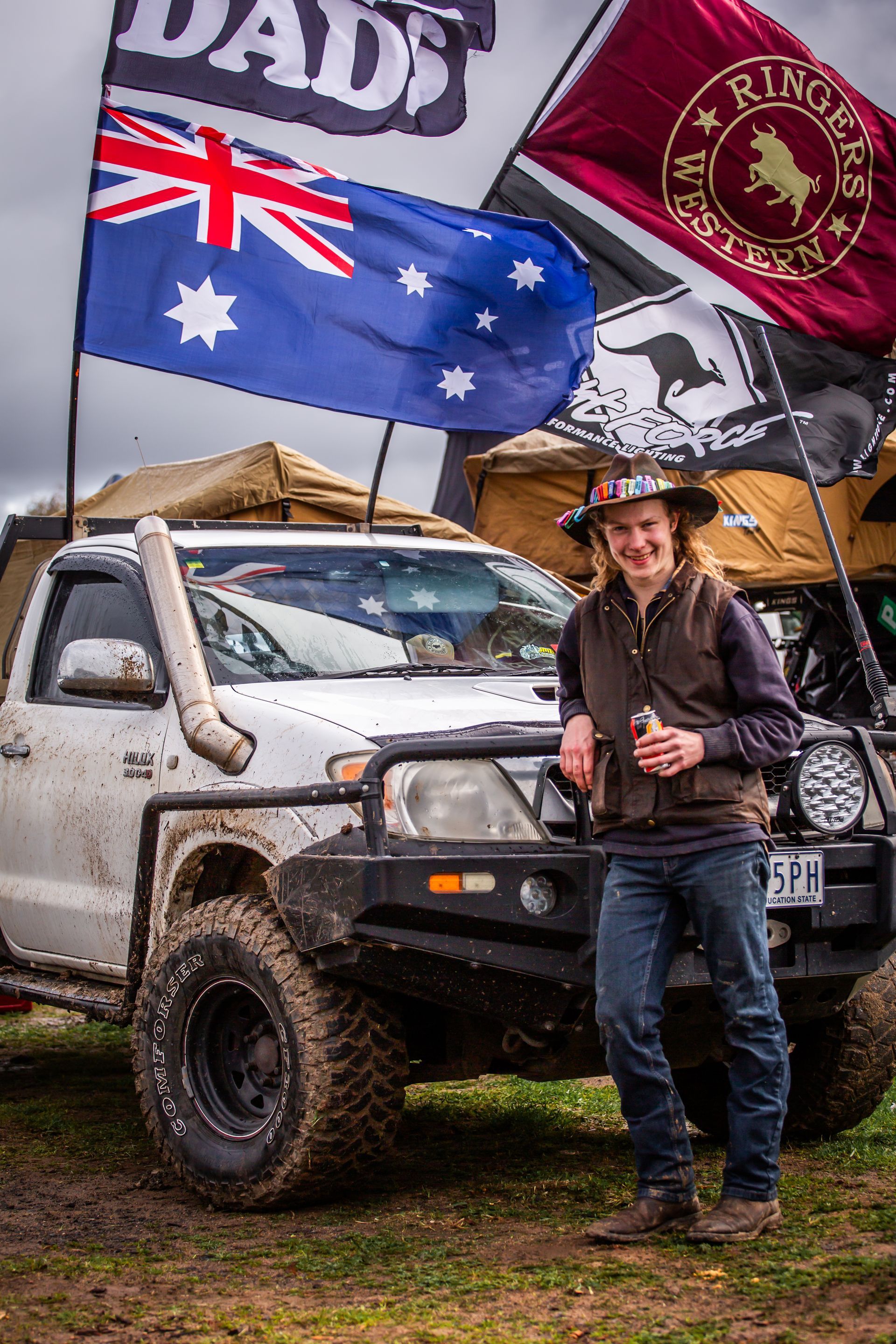 A man standing in front of a truck with a flag that says dad