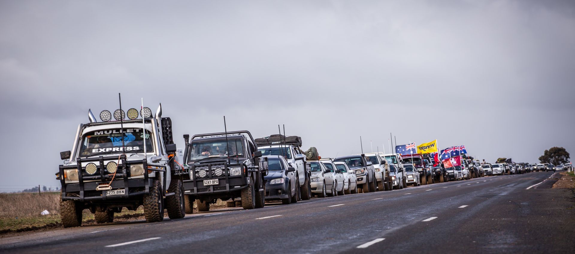 A row of cars are parked on the side of the road