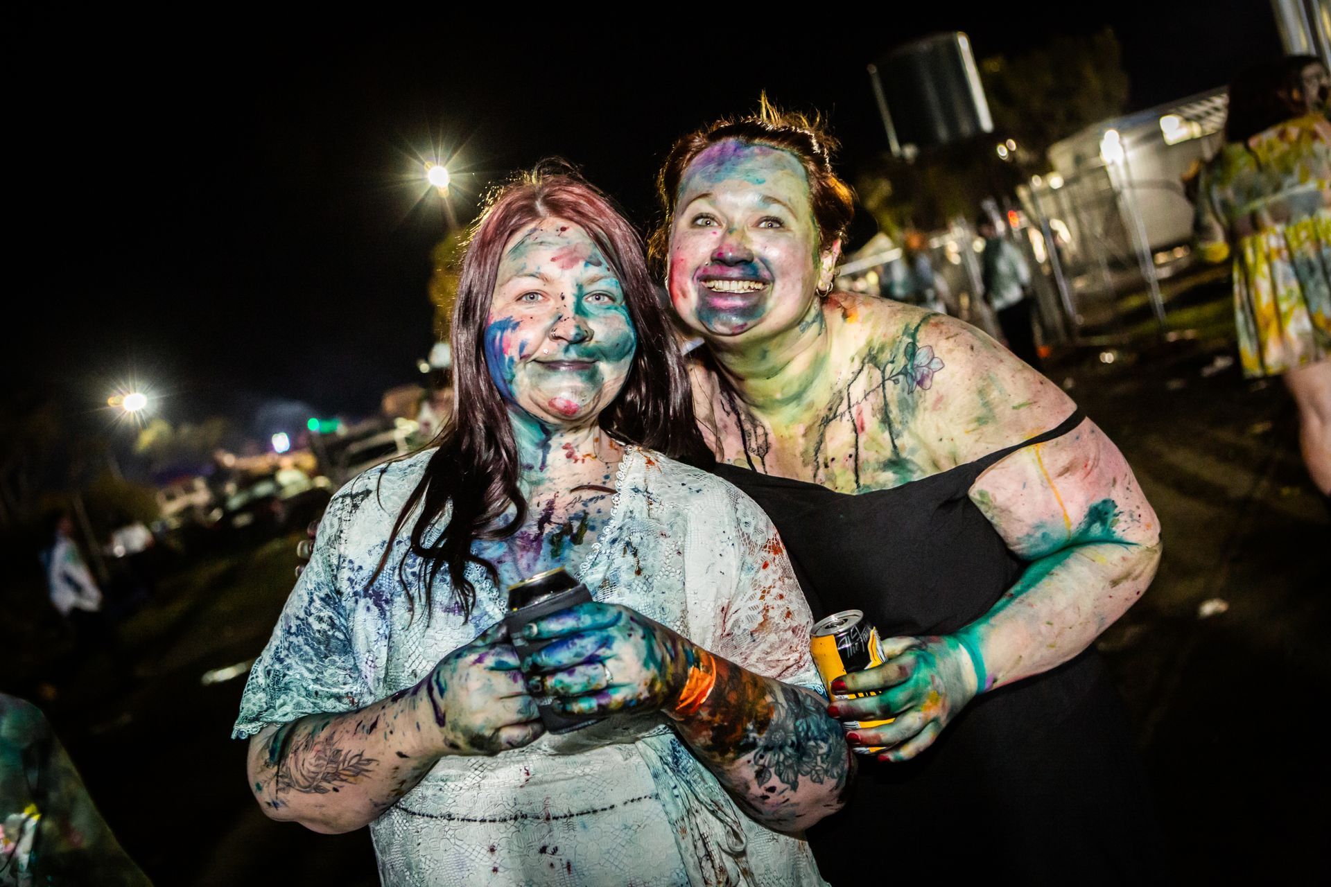Two women covered in paint are posing for a picture