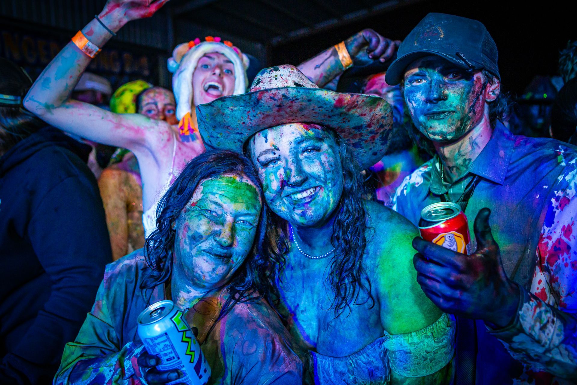 A group of people with their faces painted in different colors including blue and green