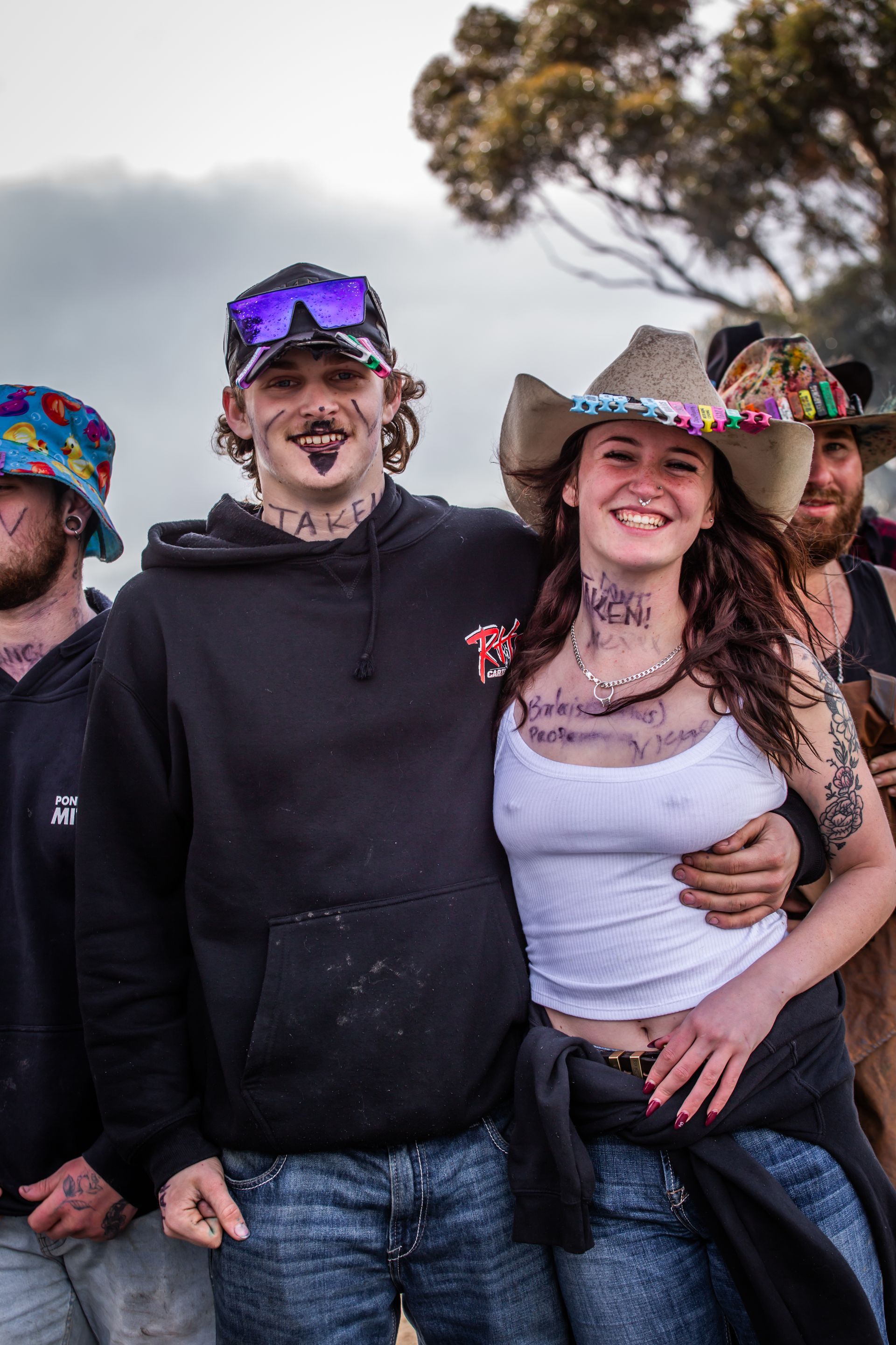 A group of people posing for a picture with one wearing a cowboy hat