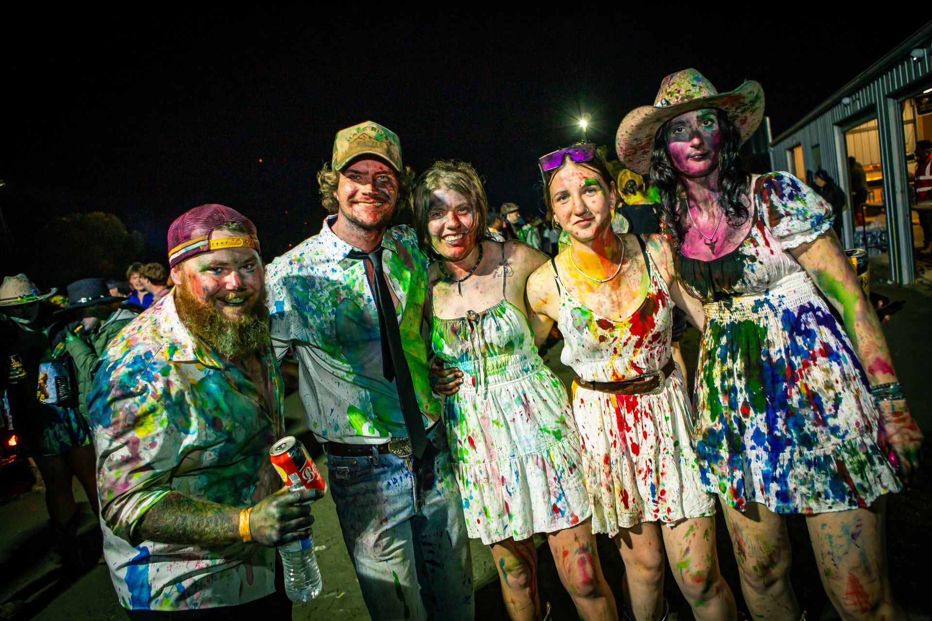 A group of people covered in paint pose for a picture