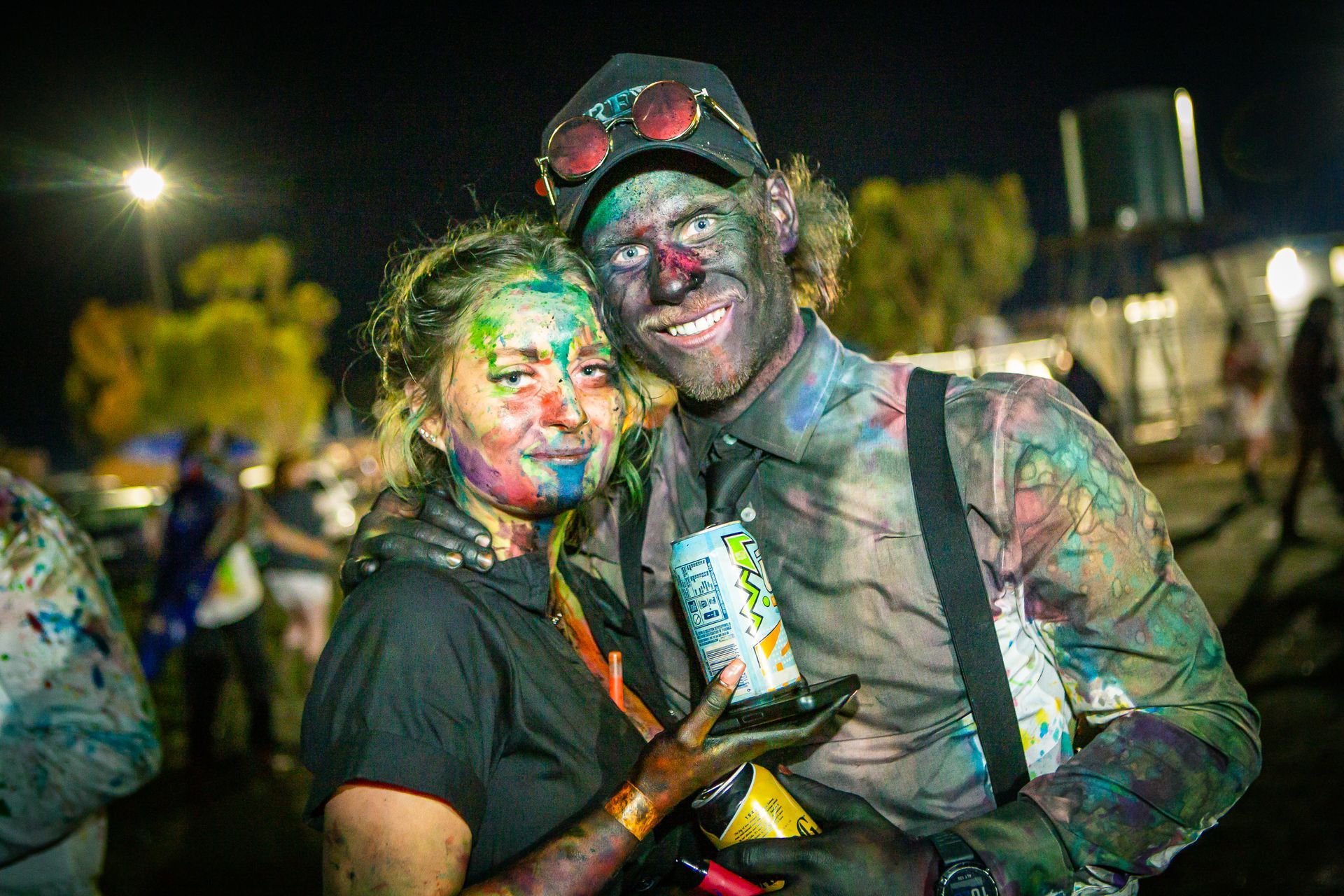 A man and a woman covered in paint are posing for a picture