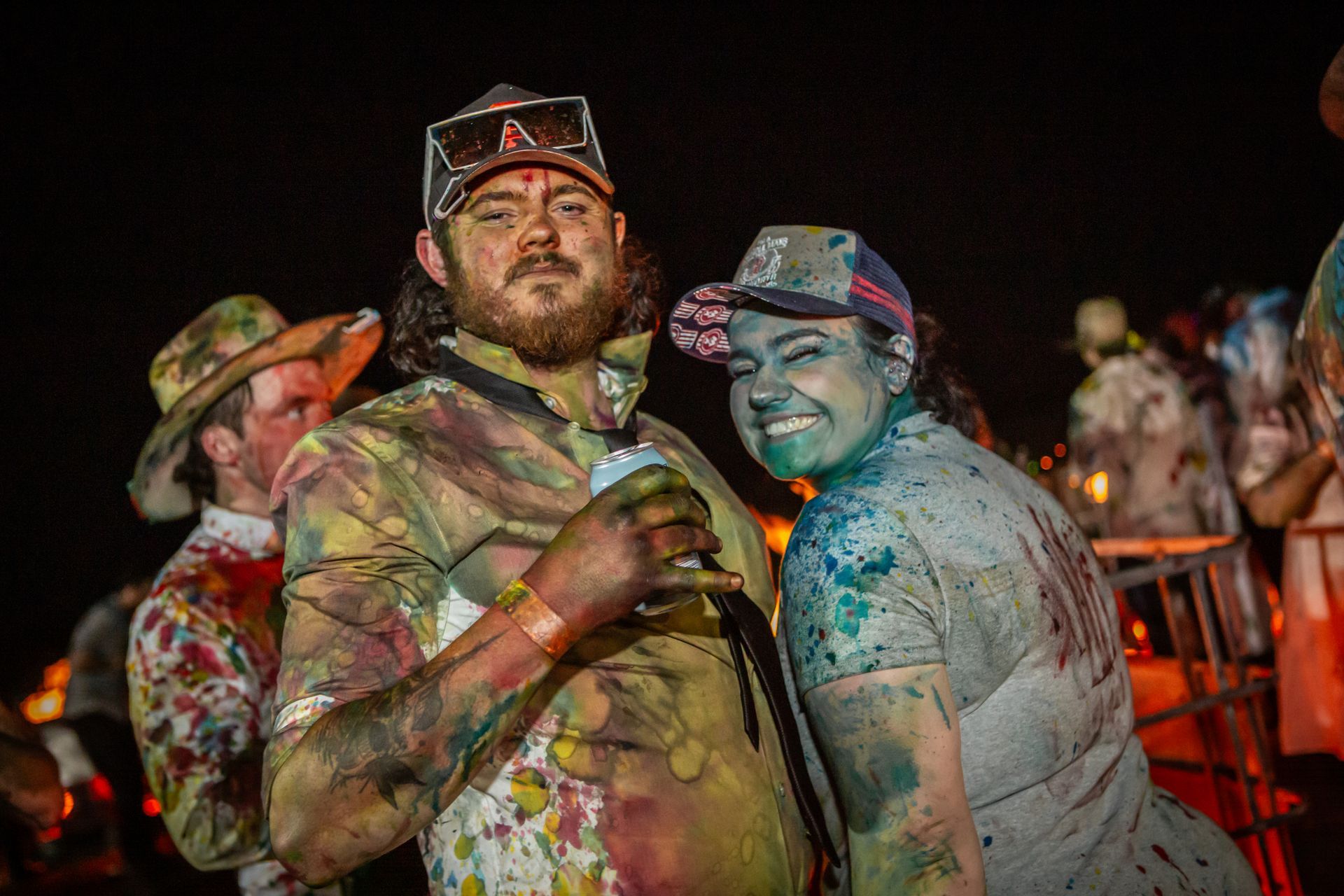 A man and a woman covered in paint are posing for a picture