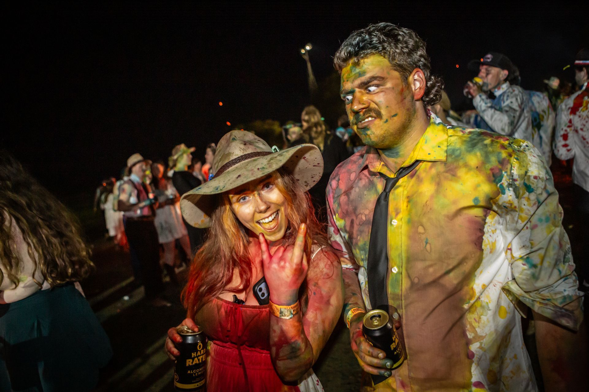 A man and a woman are covered in paint at a party