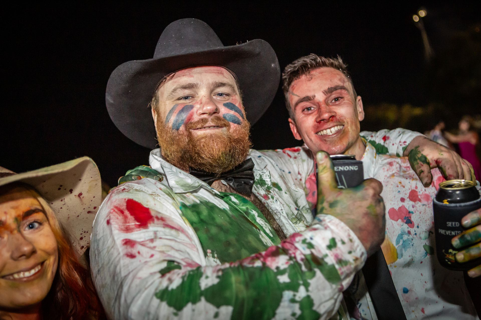 A man in a cowboy hat is giving a thumbs up