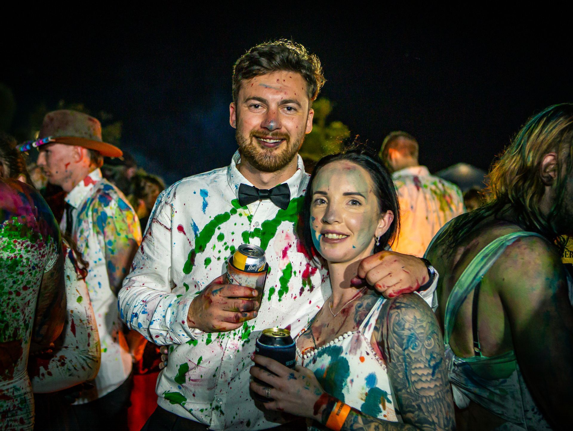 A man and a woman are covered in paint at a party