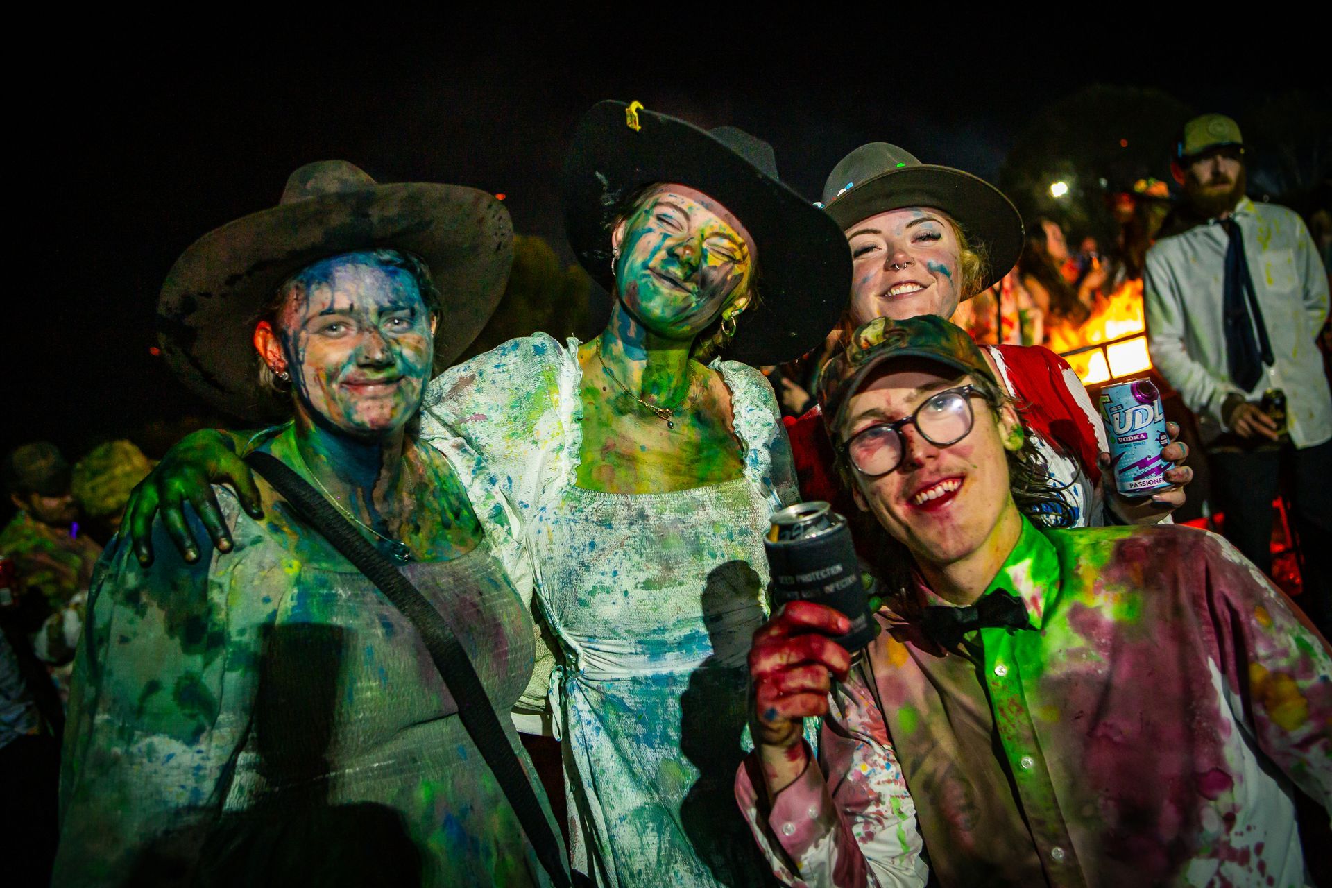 A group of people covered in paint are posing for a picture