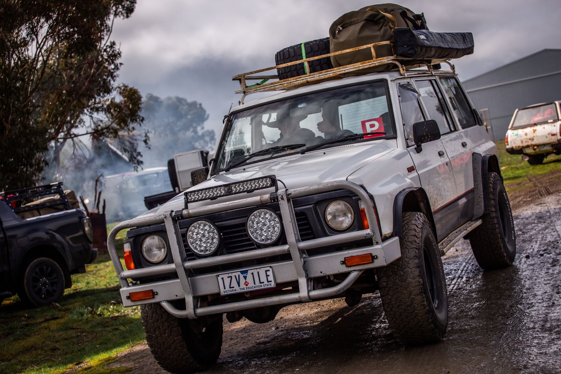 A white jeep with a roof rack and a license plate that says ' nz ' on it