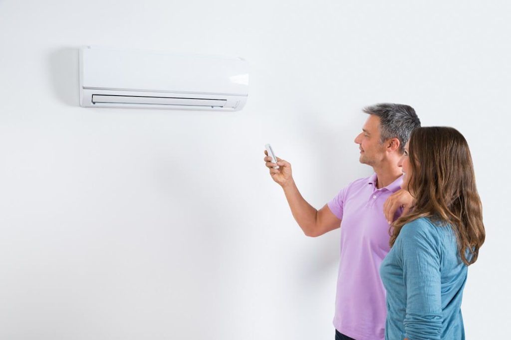 A man and a woman are looking at an air conditioner.