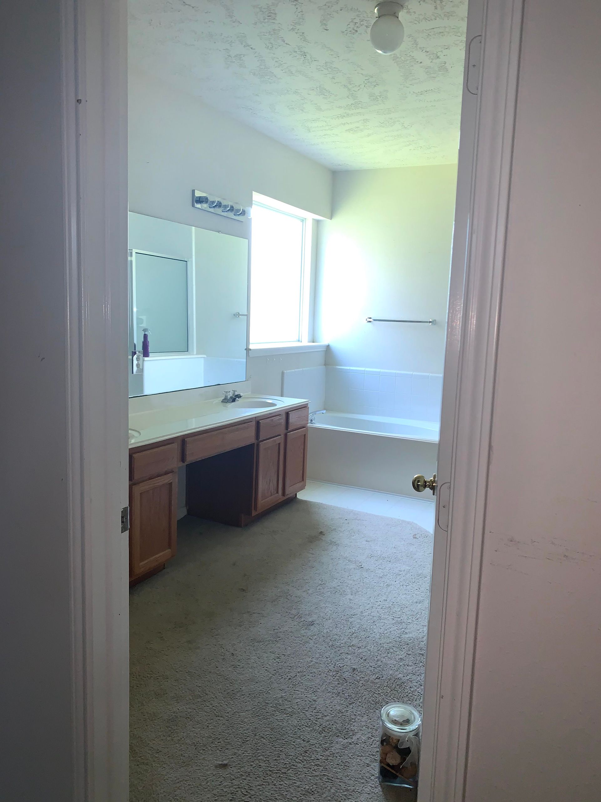 A bathroom with a tub , sink and mirror