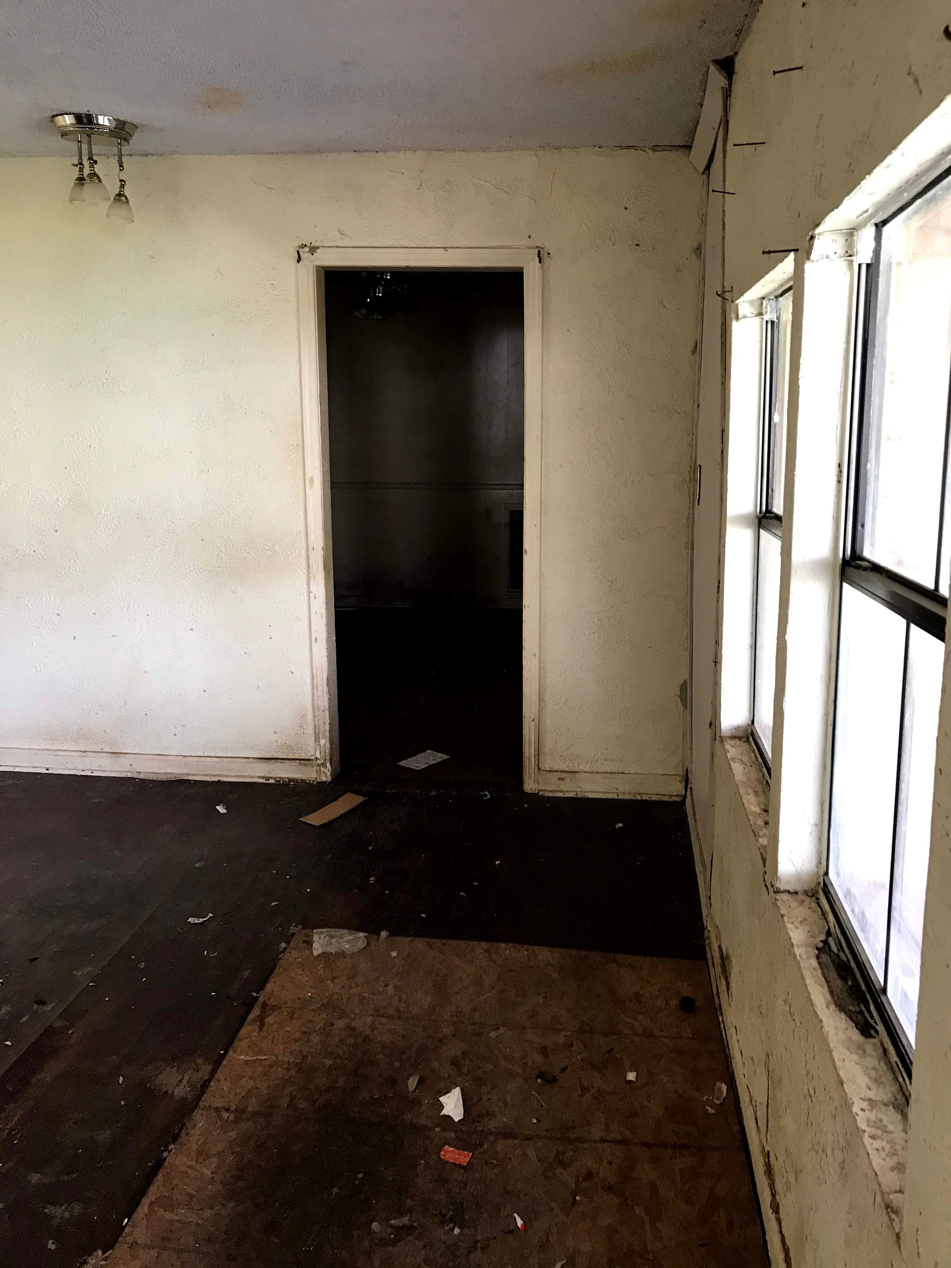 An empty room with a door and a lot of windows
