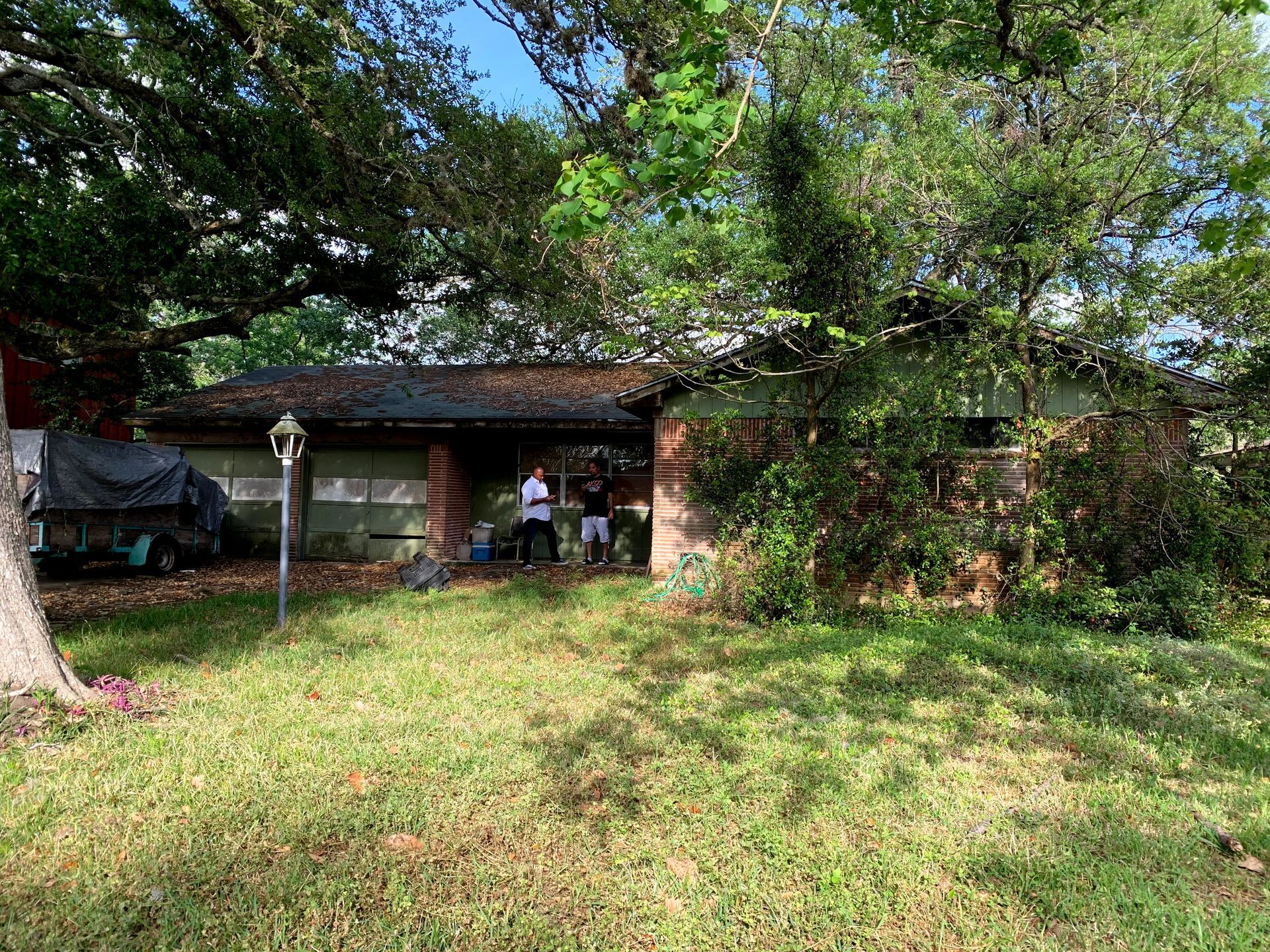 A group of people are standing in front of a house.