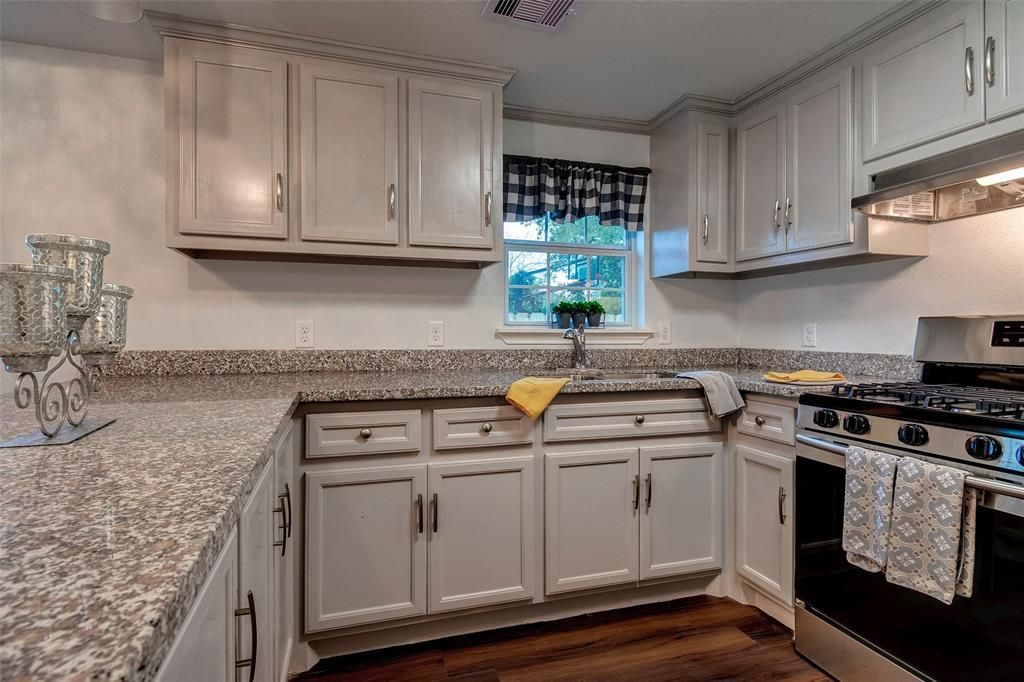 A kitchen with white cabinets and granite counter tops