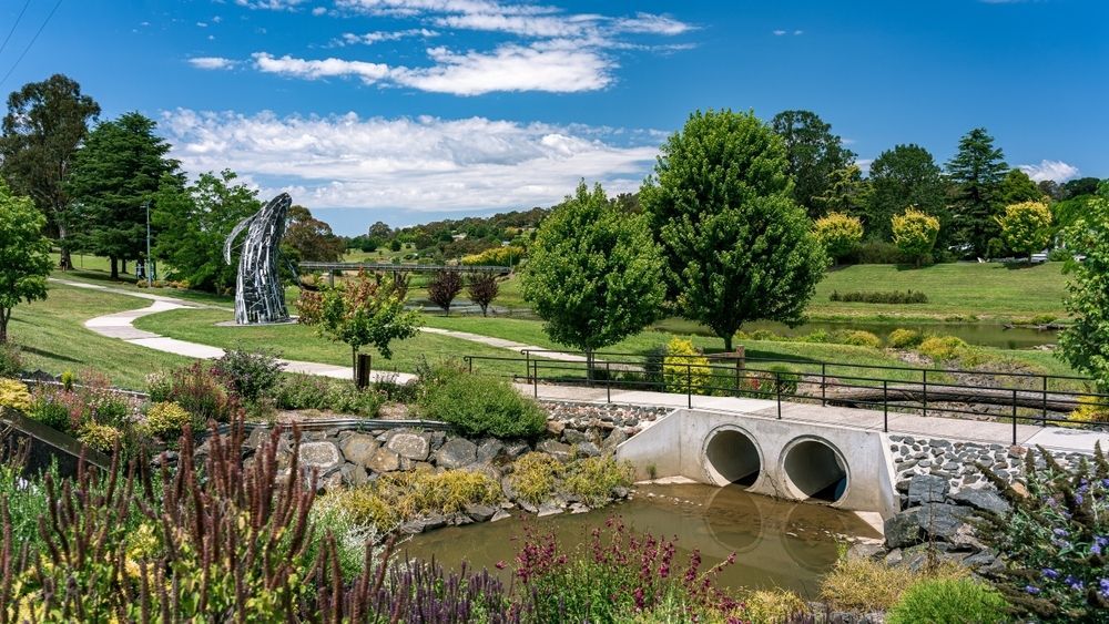 There Is A Bridge Over A Stream In The Middle Of A Park — Tamworth Muffler Man In Walcha, NSW